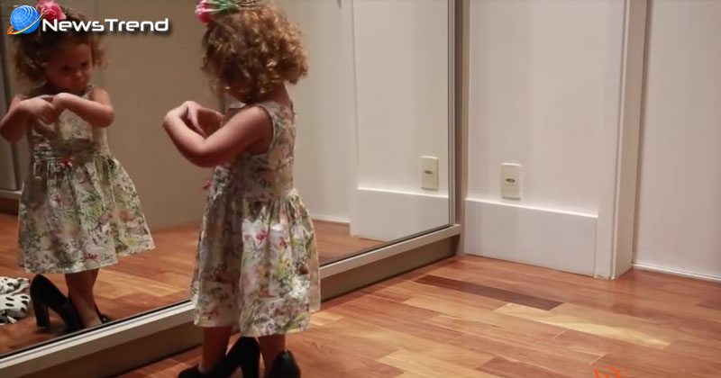 little girld dances in front of the mirror