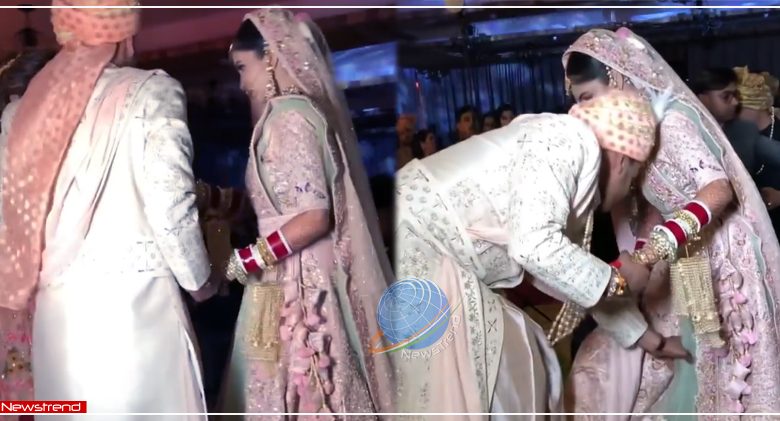 groom helps bride adjusting her lehenga